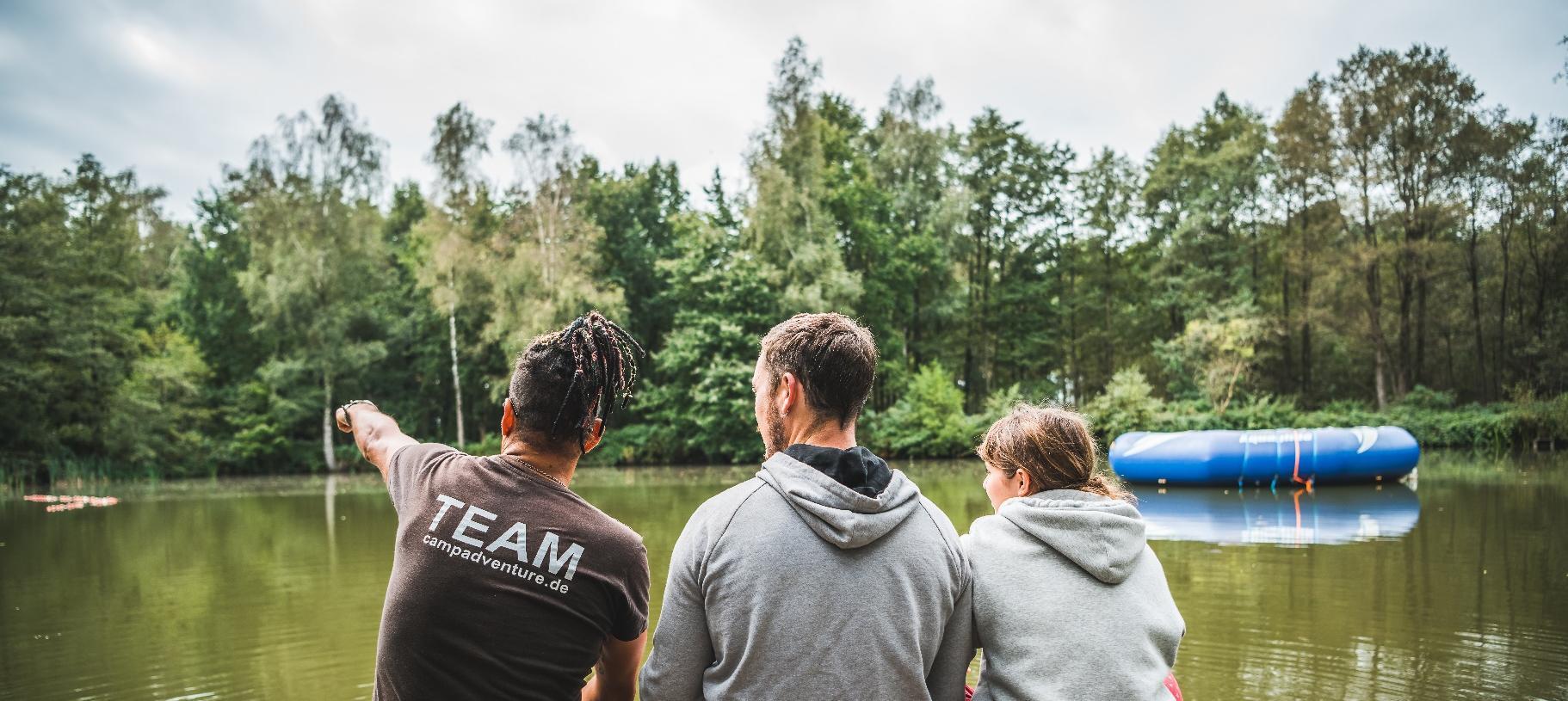 Three team members overlooking the camp lake